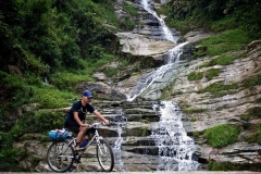 Mountain Biker in Front of Waterfall